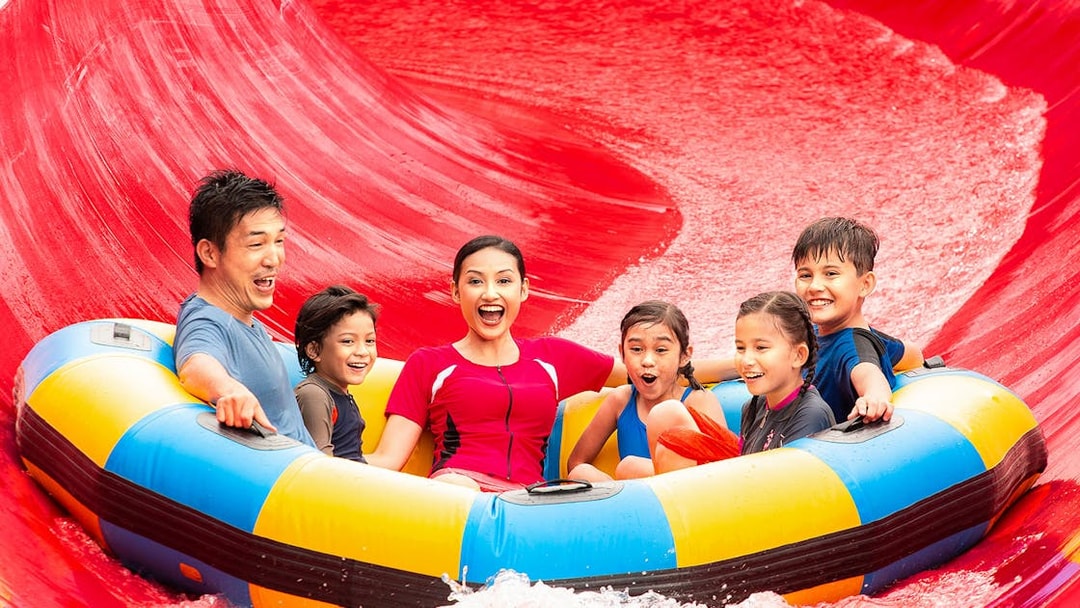 Family on a raft enjoying a water slide at LEGOLAND Malaysia Water Park.