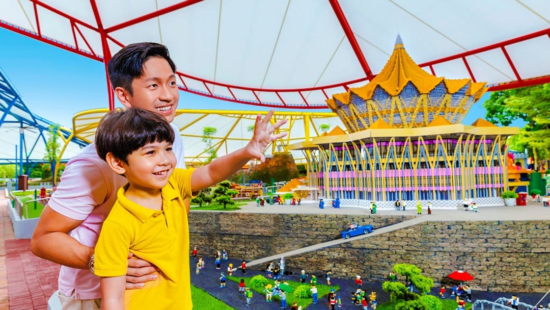 Father and son enjoying a miniature display at Legoland Malaysia theme park.