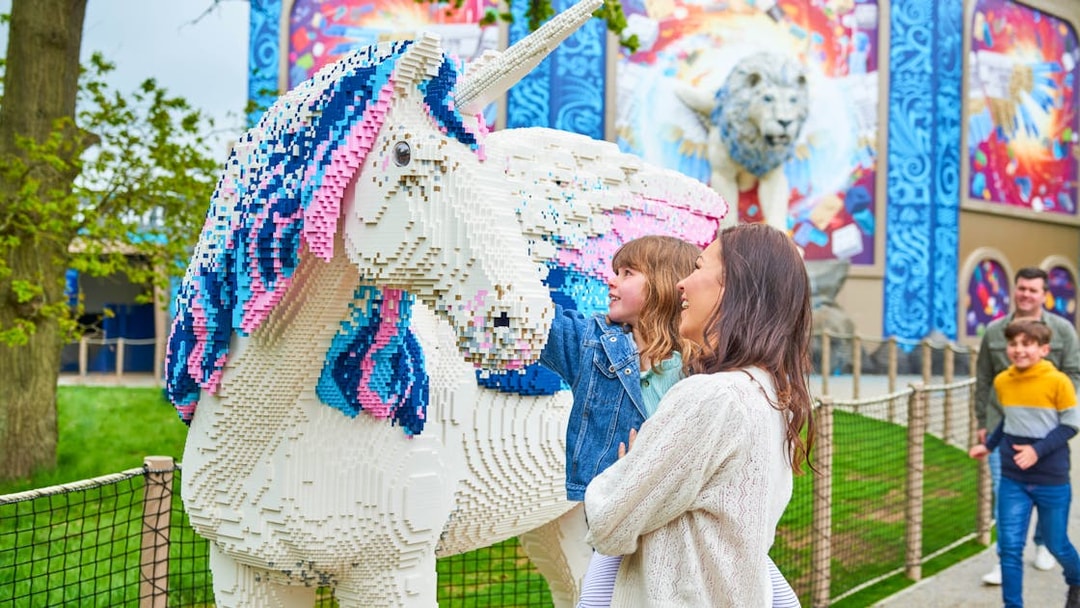 Child and adult admiring Lego unicorn at Legoland Windsor's Lego Mythica.