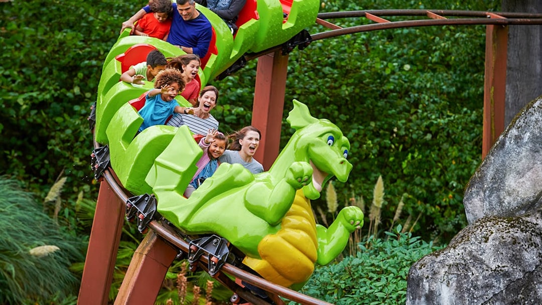 Visitors enjoying a dragon-themed roller coaster at LEGOLAND Windsor Resort.
