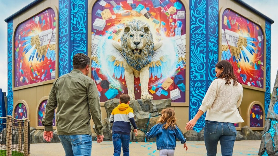 Family approaching a winged lion sculpture at LEGOLAND® Windsor Resort.