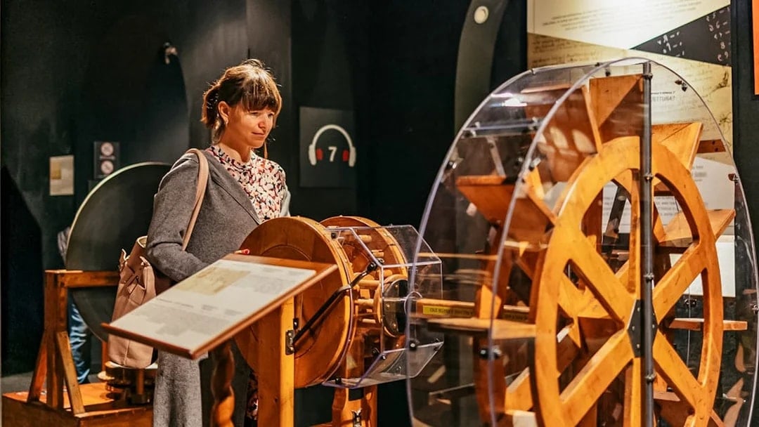 Visitor observing Leonardo da Vinci's machine model at the Leonardo Interactive Museum.