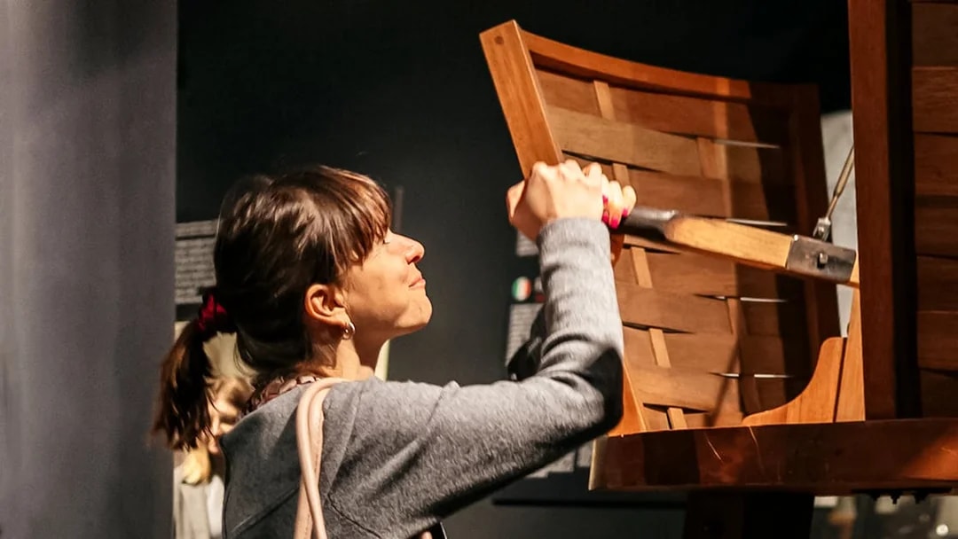 Visitor interacting with a wooden exhibit at Leonardo Interactive Museum.