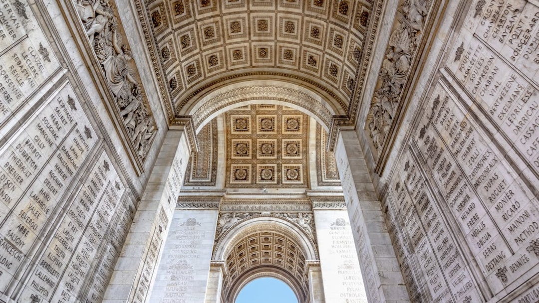 Arc de Triomphe interior with engraved names and ornate ceiling, Paris.