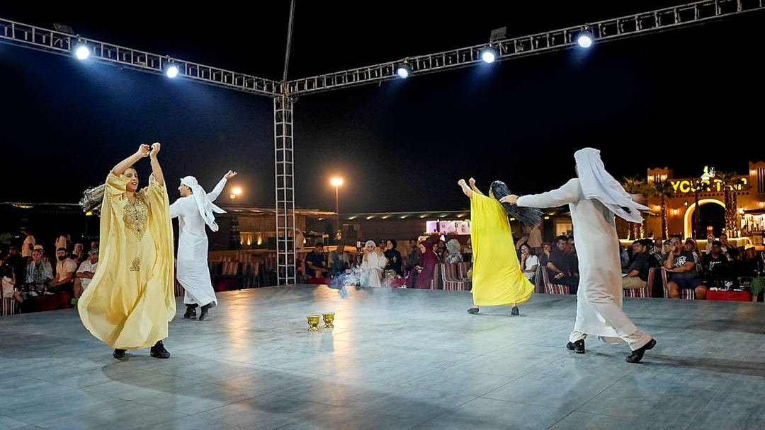 Evening desert safari with traditional dance performance under lights.