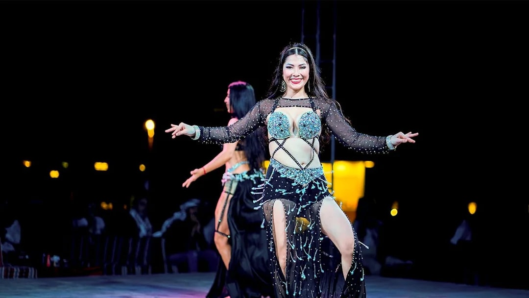 Woman dancing at Dubai desert safari experience.