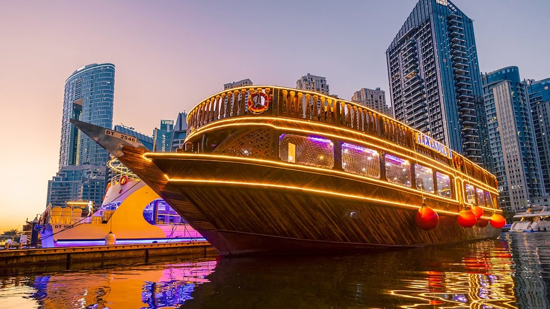 Alexandra Dhow Cruise with lights at Dubai Marina during sunset.