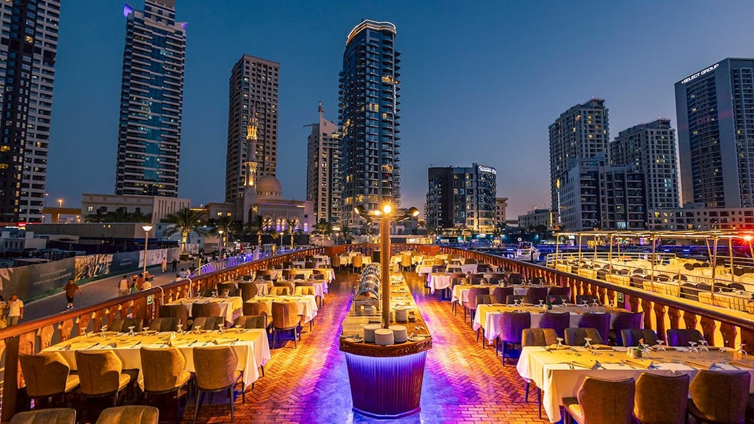 Dhow cruise dinner setup with cityscape view at Dubai Marina.