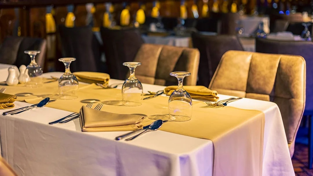 Dinner tables set with glassware and napkins on Alexandra VIP Dhow Cruise.