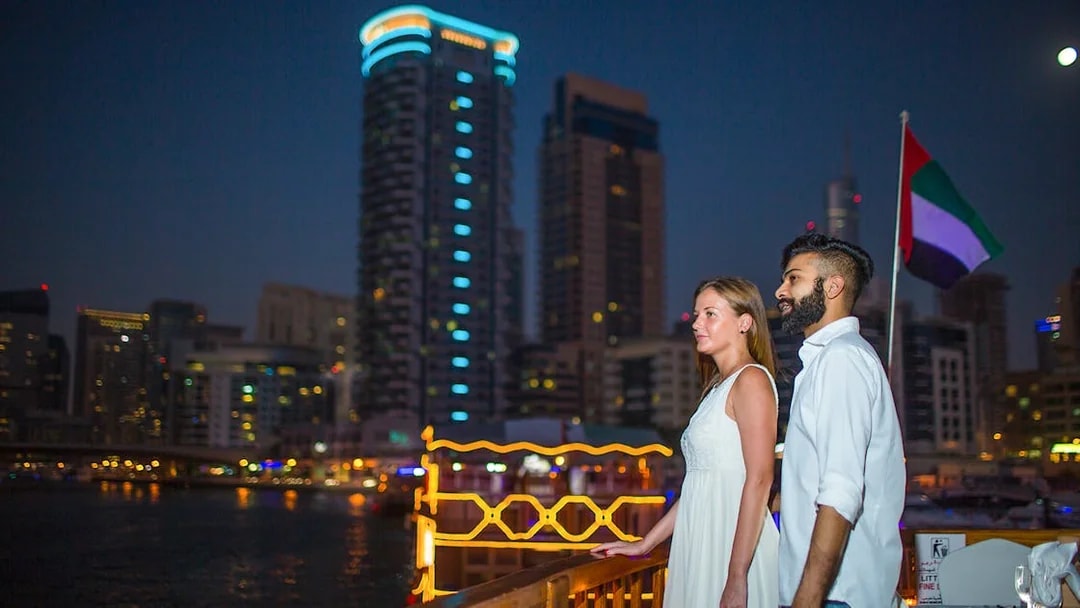 Couple enjoying Marina skyline from Alexandra VIP Dhow Cruise in Dubai.