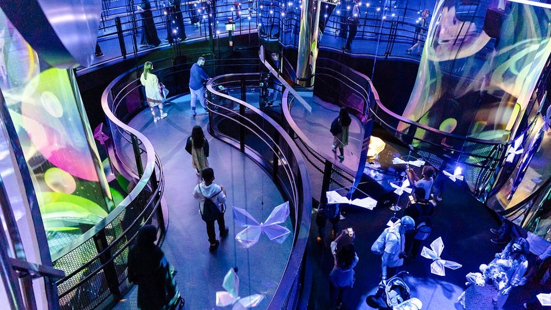 Tourists walking through illuminated exhibit at Expo City Dubai.