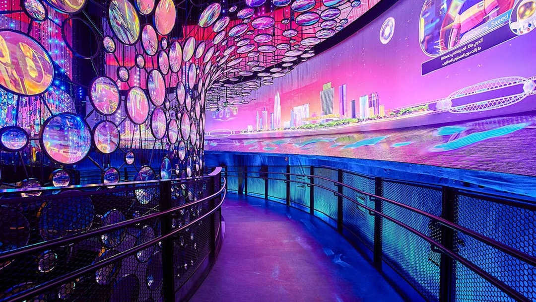 Exhibit with colorful lights and cityscape at Expo City Dubai.