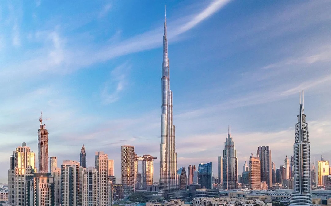 Burj Khalifa towering over Dubai skyline at sunset.