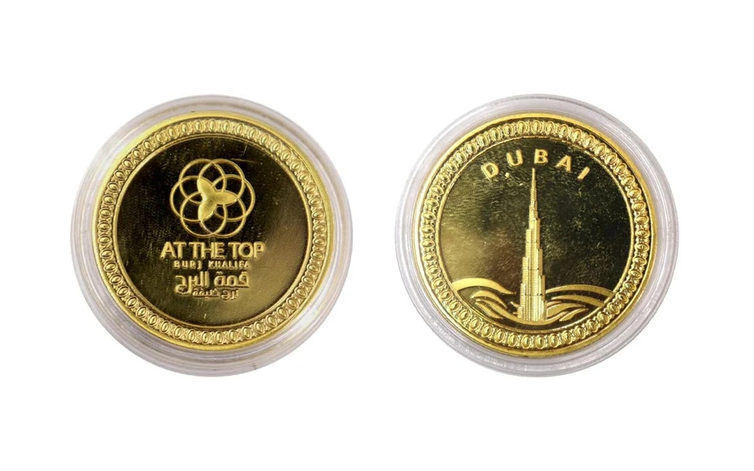 Gold coin featuring Burj Khalifa and "At The Top" logo, Dubai.