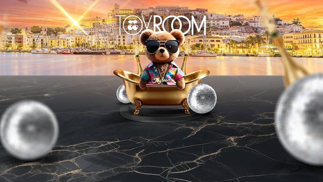 Toy Room bear in a gold tub with disco balls, Ibiza marina backdrop at sunset.