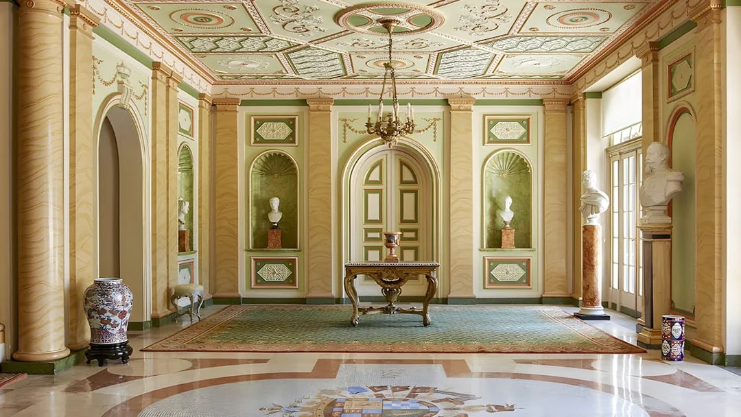 Interior of Liria Palace in Madrid featuring ornate ceiling, busts, and decorative columns.
