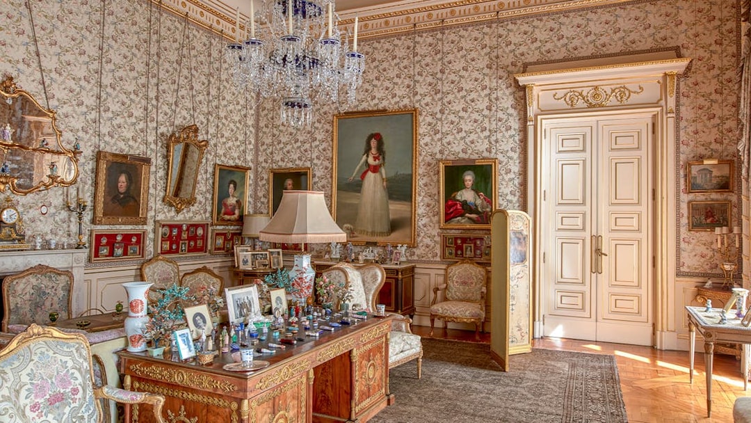 Photos and paintings in an ornate room at Liria Palace, featuring classic furniture and decor.