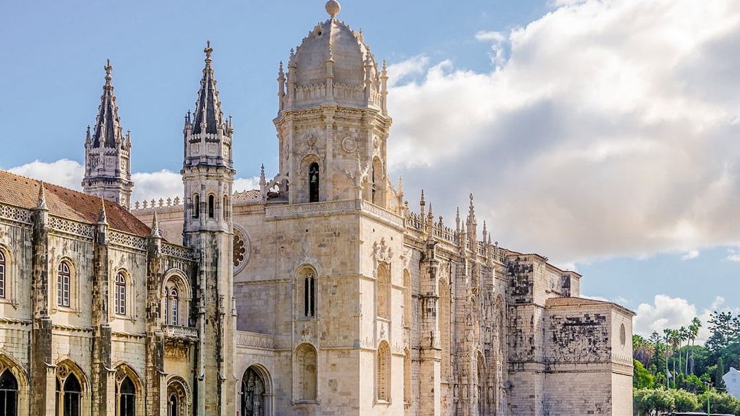 Jerónimos Monastery in Lisbon, Portugal, with ornate Gothic architecture on a sunny day.
