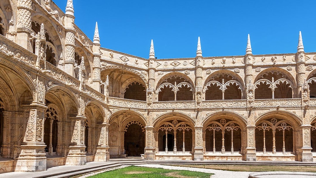 Monastery of Jeronimos Cloister entrance with ornate arches, Lisbon, Portugal.