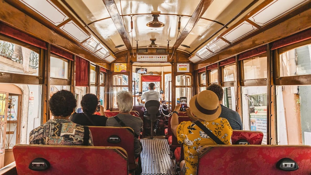 Tourists photographing views from inside a Lisbon tramcar.