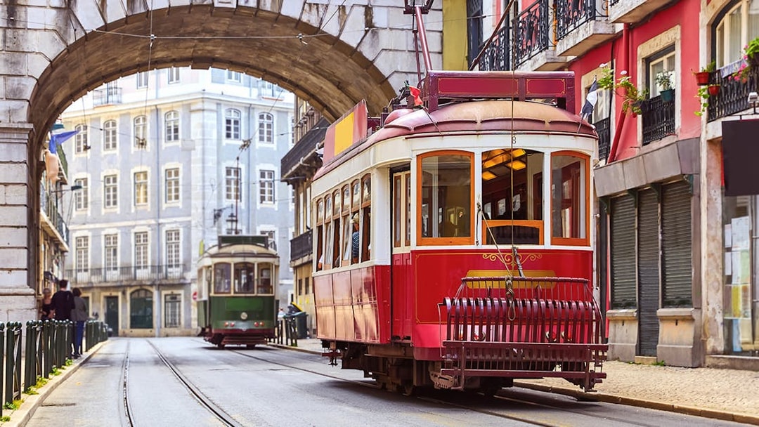Tramcar passing under arch in Alfama district, Lisbon.