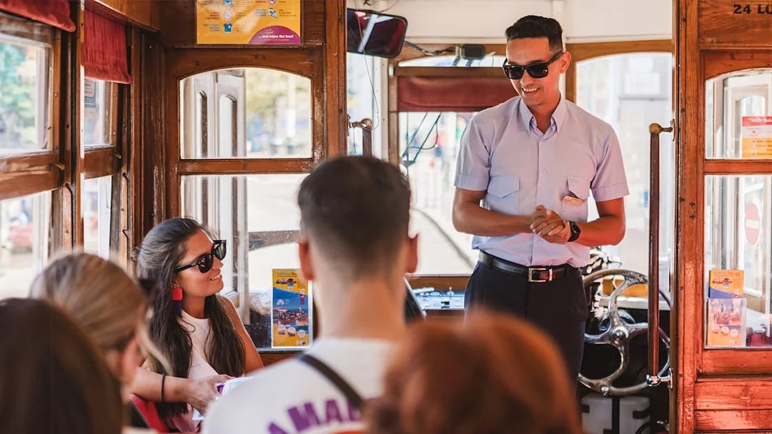 Tram conductor addressing passengers inside a Lisbon tram.