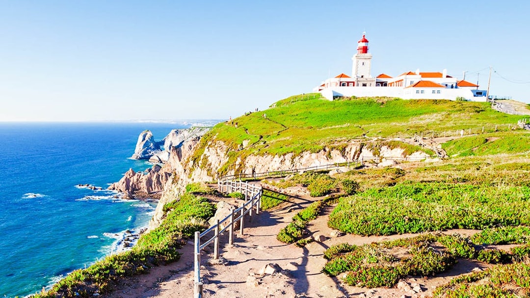 Cabo da Roca lighthouse on a cliff overlooking the Atlantic Ocean, part of a Lisbon day tour.