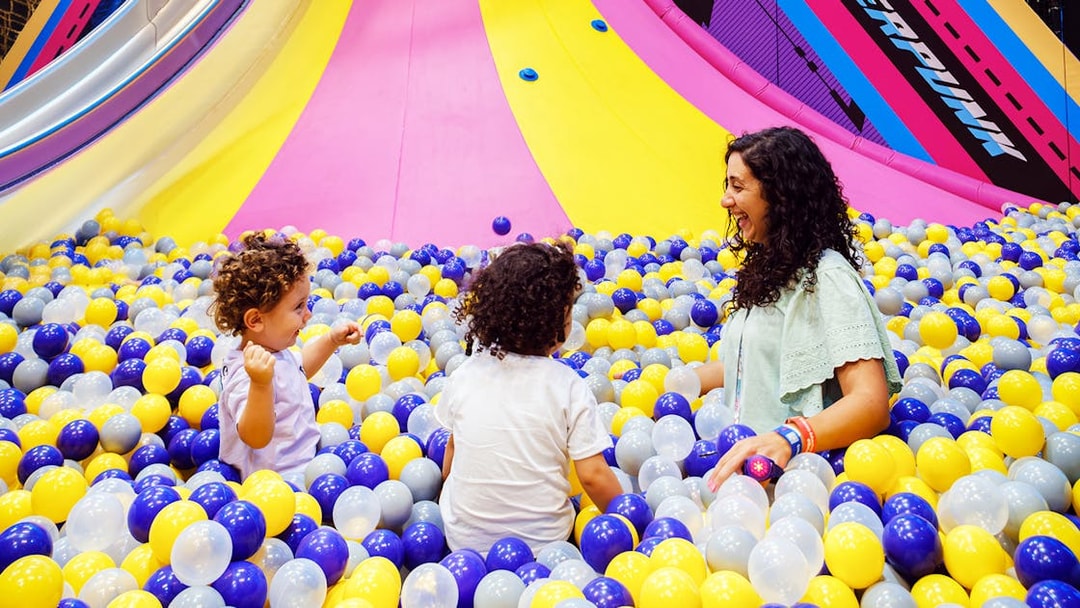 Children and adult playing in a colorful ball pit at Loco Bear entertainment hub.