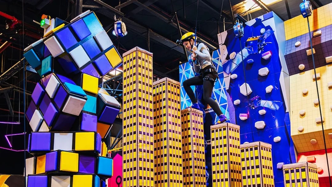 Climber navigating colorful obstacle course at Loco Bear Entertainment Hub.