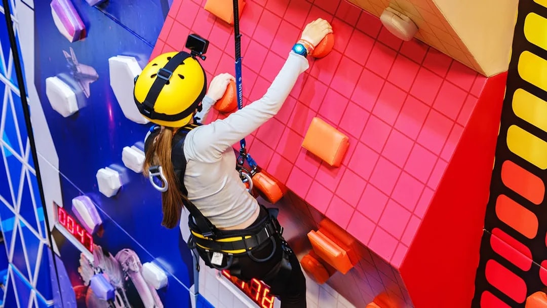 Climber on indoor wall at Loco Bear Entertainment Hub.
