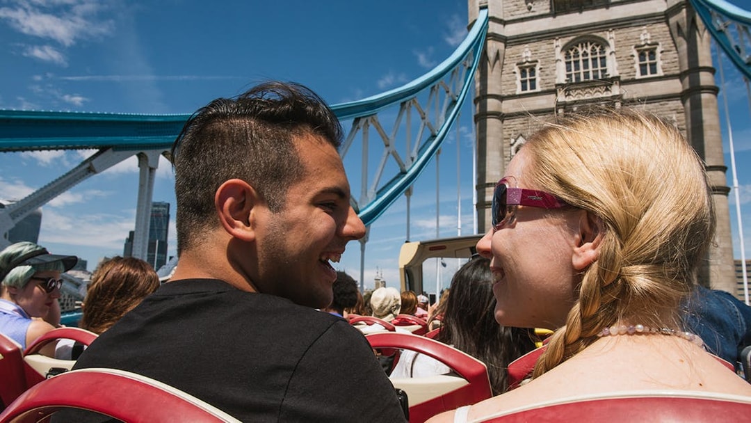 Open-top bus tour crossing Tower Bridge in London.