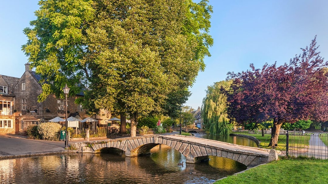 Stone bridge over river in Cotswolds village, part of Blenheim Palace and Downton Abbey tour.