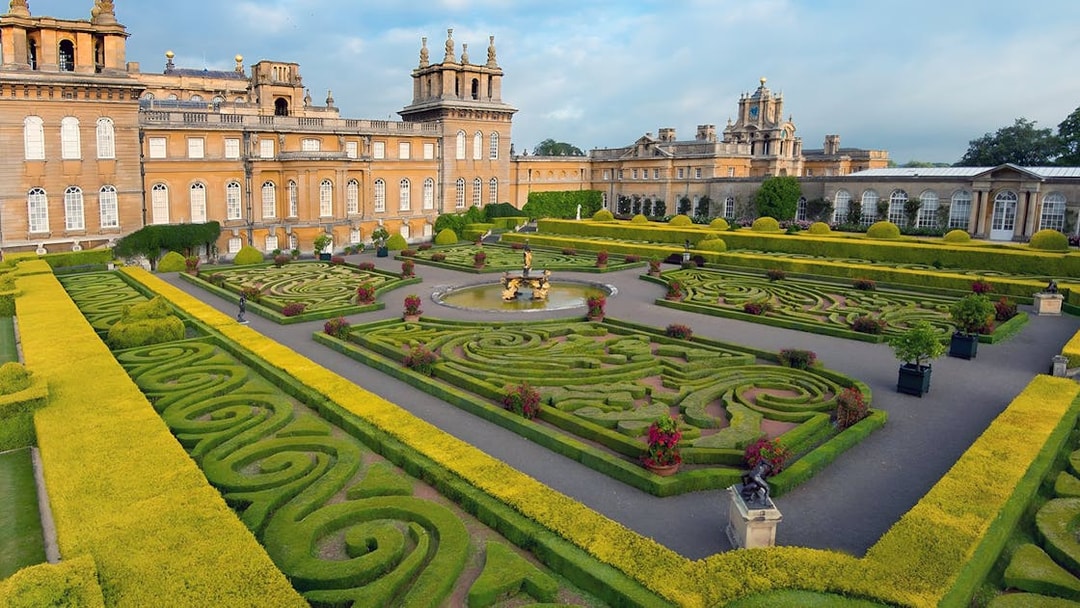 Blenheim Palace gardens with intricate hedges and fountain, part of Downton Abbey Village & The Cotswolds Tour.