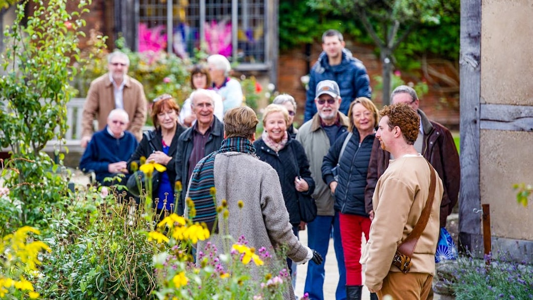 Group enjoying a guided tour in a garden setting.