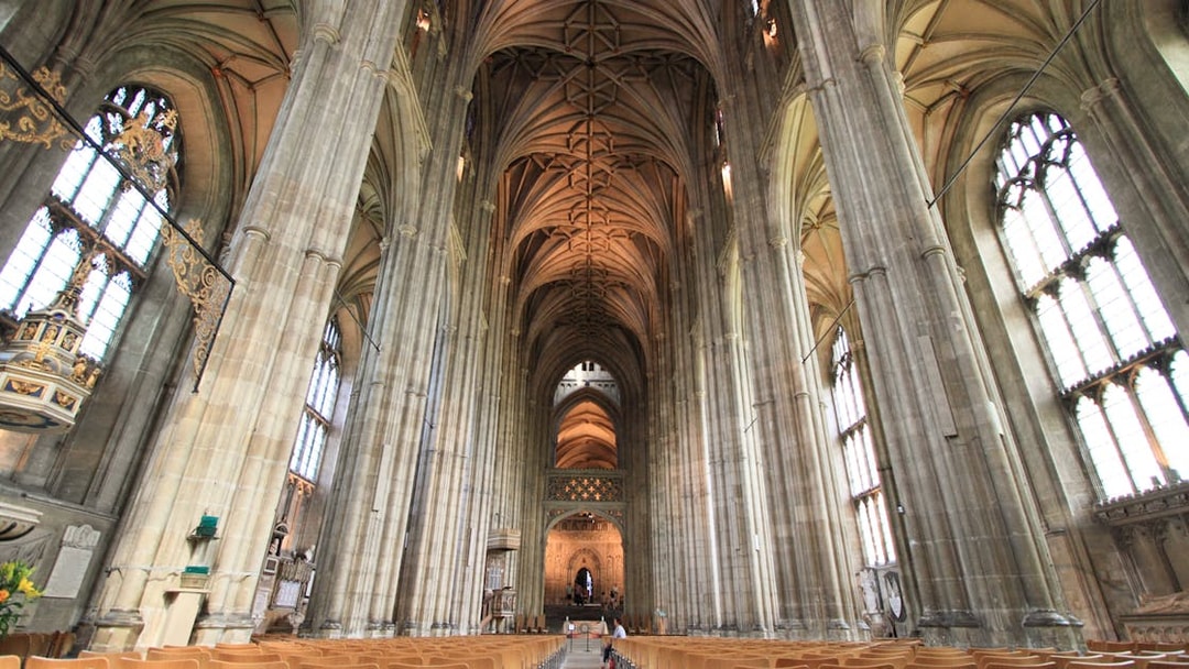 Interior of Canterbury Cathedral with vaulted ceilings and stained glass windows, part of the Canterbury and Dover tour.