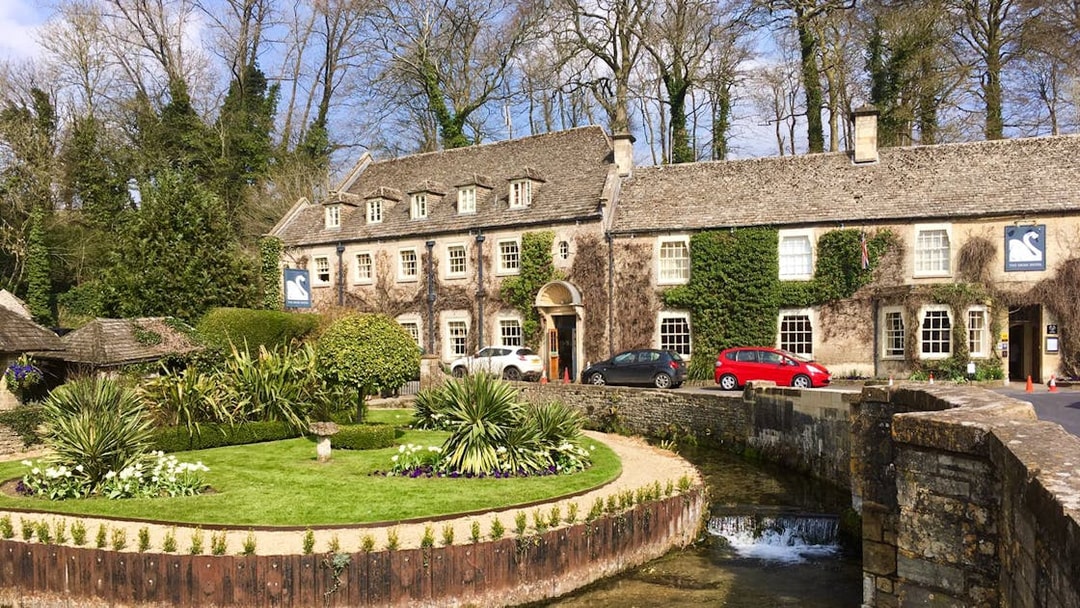 Cotswolds stone building with ivy, garden, and stream in front, near Broadway Tower, England.