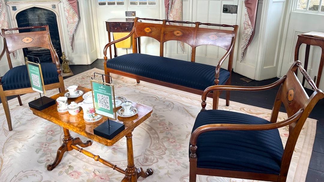 Elegant tea set on wooden table in historic room at Broadway Tower, Cotswolds tour from London.