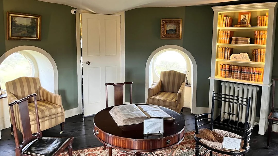 Interior of Broadway Tower with vintage furniture and bookshelves, Cotswolds tour from London.