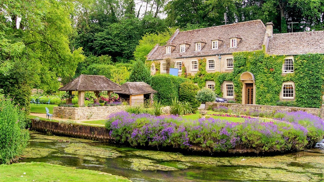 Cotswolds village house with ivy, garden, and stream on small group tour.