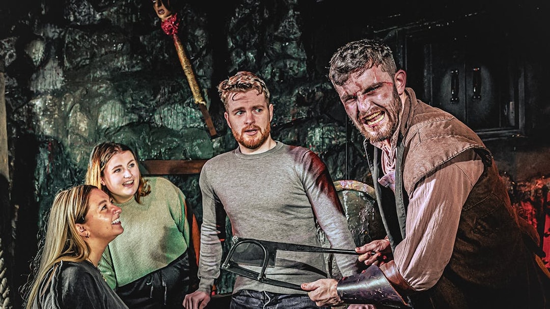 Guests interacting with actor in London Dungeon Torture Chamber.