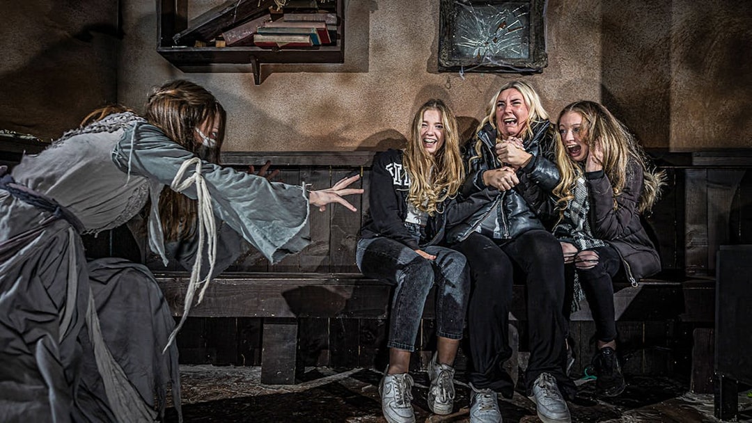 Visitors react to a costumed actor at the London Dungeon VIP experience.