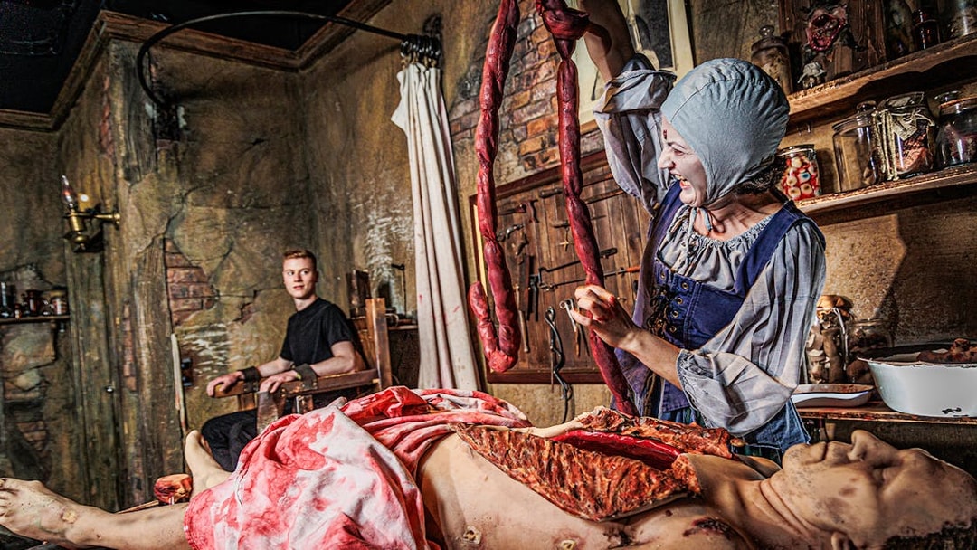 Actor in period costume performing surgery scene at London Dungeon.