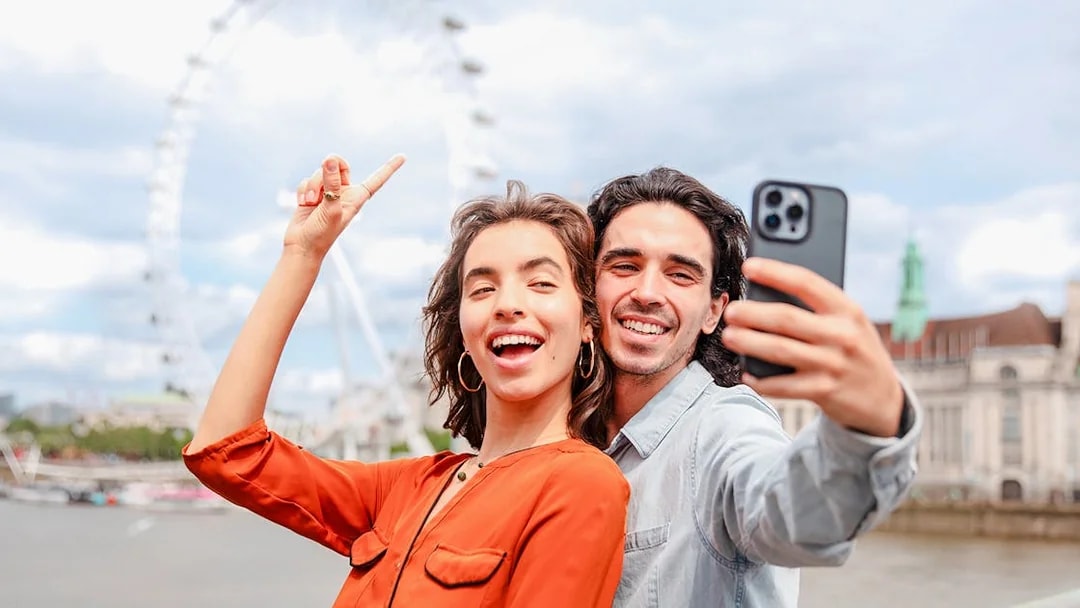 Couple taking a selfie with the London Eye in the background during a champagne experience.