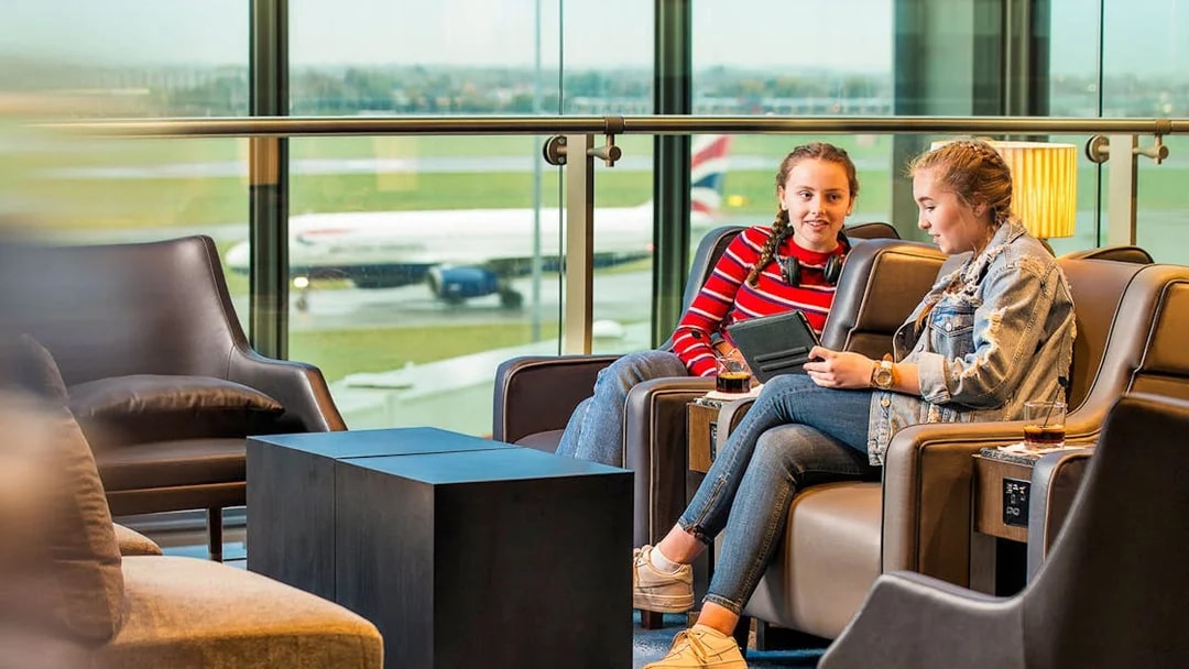 Heathrow Plaza Premium Lounge with travelers relaxing and viewing the runway.