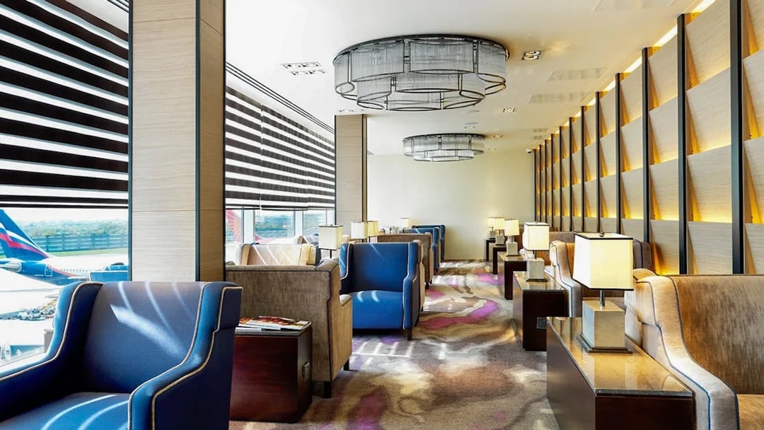 Heathrow Plaza Premium Lounge seating area with armchairs and tables near large windows.