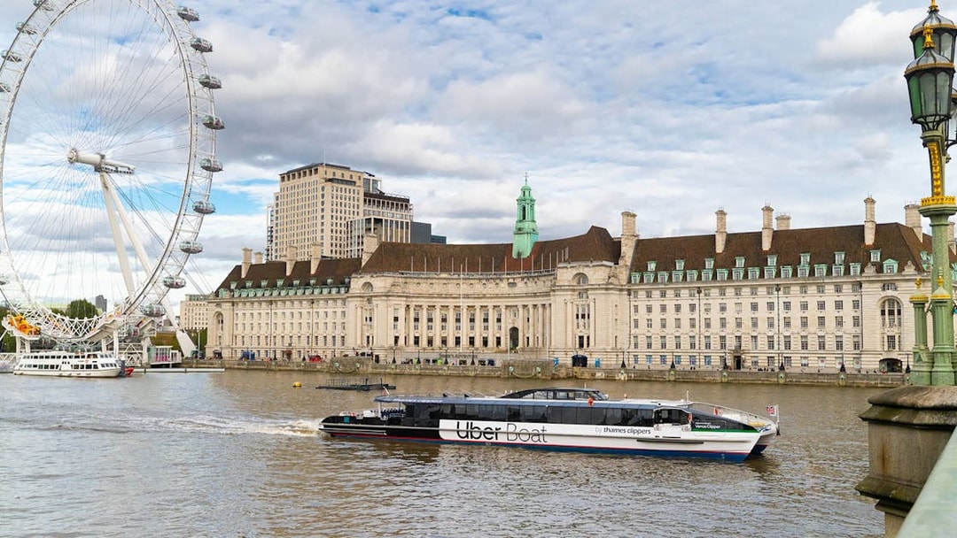 London Eye and County Hall viewed from a Thames Clippers boat on the River Thames.
