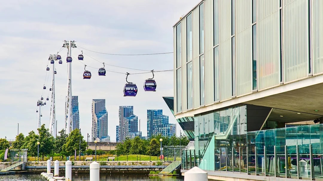 IFS Cloud Cable Car over River Thames in London with city skyline in background.