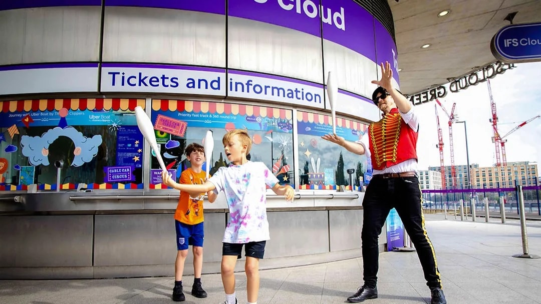 Guests juggling at IFS Cloud Cable Car ticket area in London.