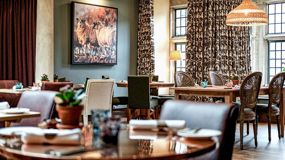 Country pub dining area with rustic decor in the Cotswolds, featuring tables set for lunch.