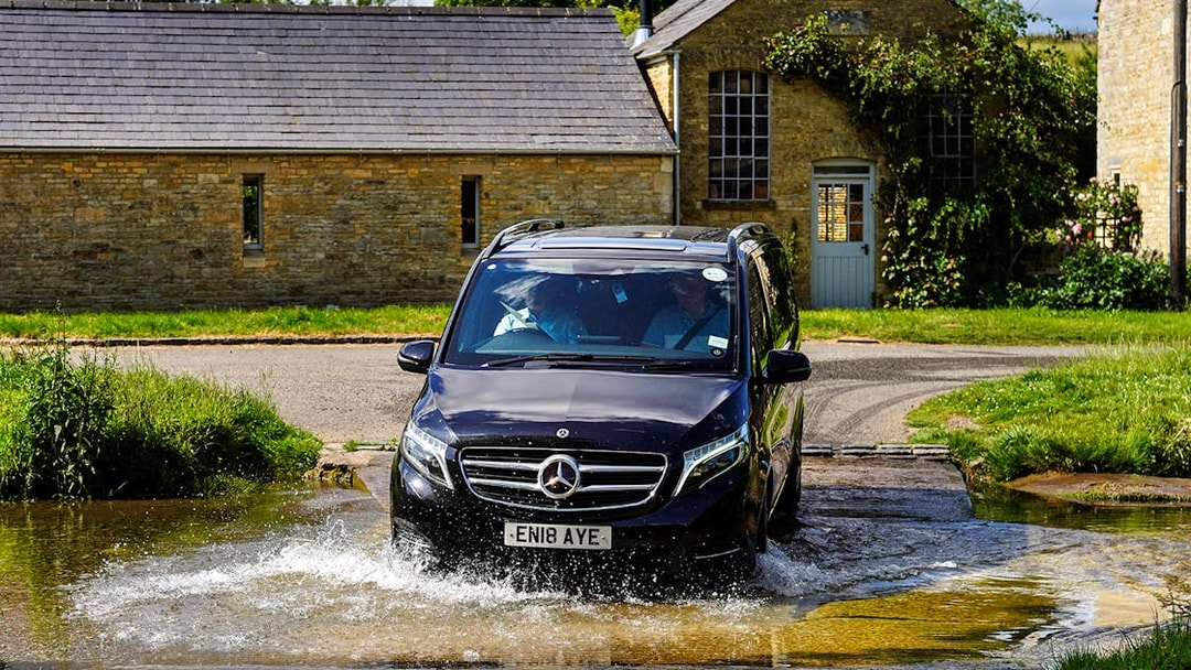 Van crossing a shallow stream in the Cotswolds countryside near Oxford.